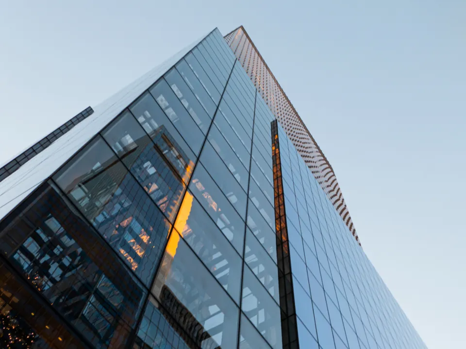 A glass office tower catching low evening light